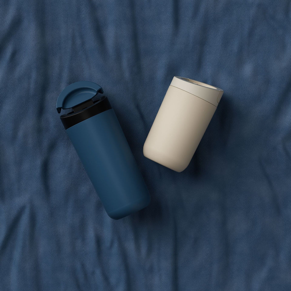 350-500ml Two-Lid Coffee Cup, Direct Drink and Straw Caps, Car Cup Holder Fit. Blue and beige coffee cups photographed on dark fabric.