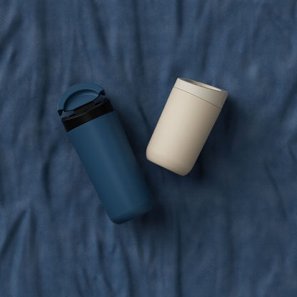 350-500ml Two-Lid Coffee Cup, Direct Drink and Straw Caps, Car Cup Holder Fit. Blue and beige coffee cups photographed on dark fabric.
