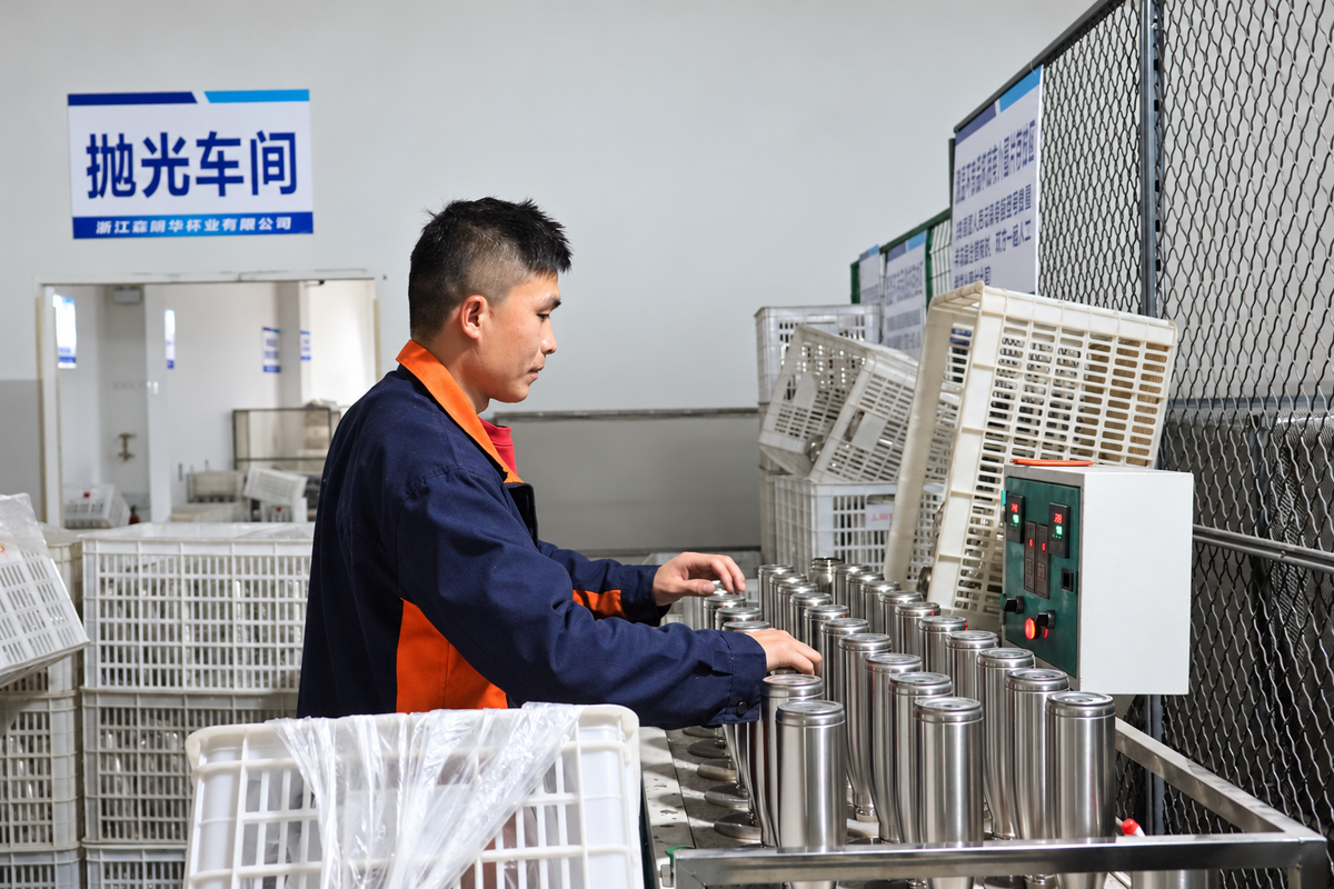 Operator polishing stainless-steel drinkware in the finishing area
